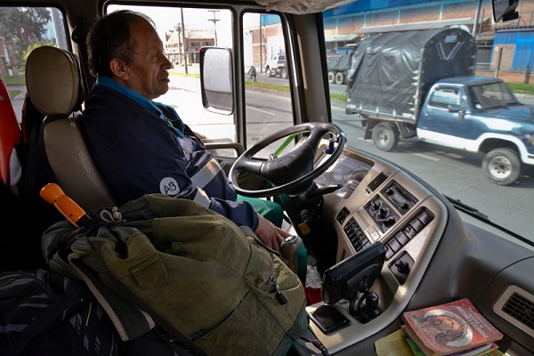 Jose Alberto Gutierrez drives a garbage truck through the streets of Bogota, on May 26, 2017.  Bogota has who rescues its books. For more than two decades Jose Alberto Gutierrez - "The Lord of Books", as he is known in Colombia - drives a garbage truck through the gray and cold streets of Bogota. In addition to wastes, he has collected thousands of books that crowded into his home, converted into a free library. / AFP PHOTO / GUILLERMO LEGARIA COLOMBIA-SOCIETY-BOOKS-RESCUER