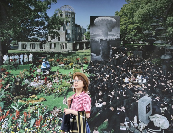 A woman walks past in front of picture of Hiroshima created by Masashiro Usami in the part of T3(Talent,Technology,Tolerance) Photo festival Tokyo at Ueno Park in Tokyo, Friday, May 26, 2017. (AP Photo/Koji Sasahara)